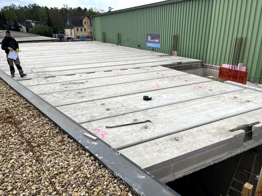 Monteur prüft Spannbetonplatten nach der Verlegung