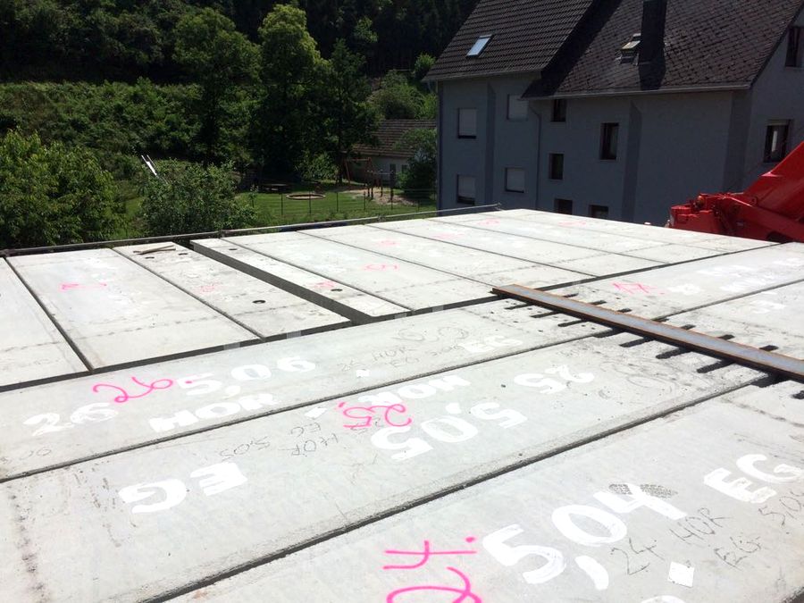 Spannbeton-Hohlplatten werden mit Kran auf Stahlbaukonstruktion gehoben
