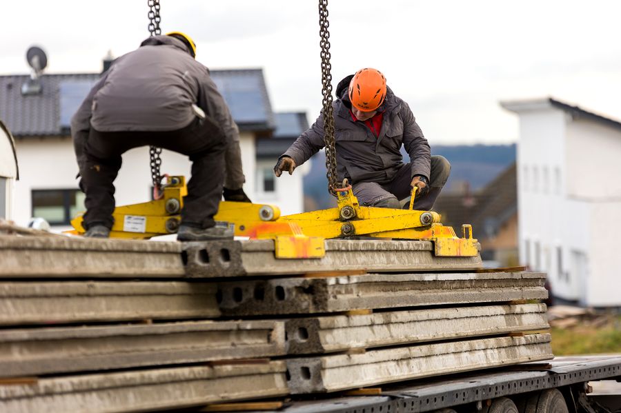 Montage Betonfertigdecke – Arbeiter sichert Hohlplatte bei Verlegung